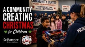 Volunteer presents a toy to a smiling child during Rockin' for Kids' annual holiday toy drive benefiting local children and families.