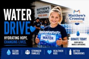 Child holding a case of bottled water during a Rockin' for Kids Water Drive at Matthew's Crossing Food Bank, helping families in need.
